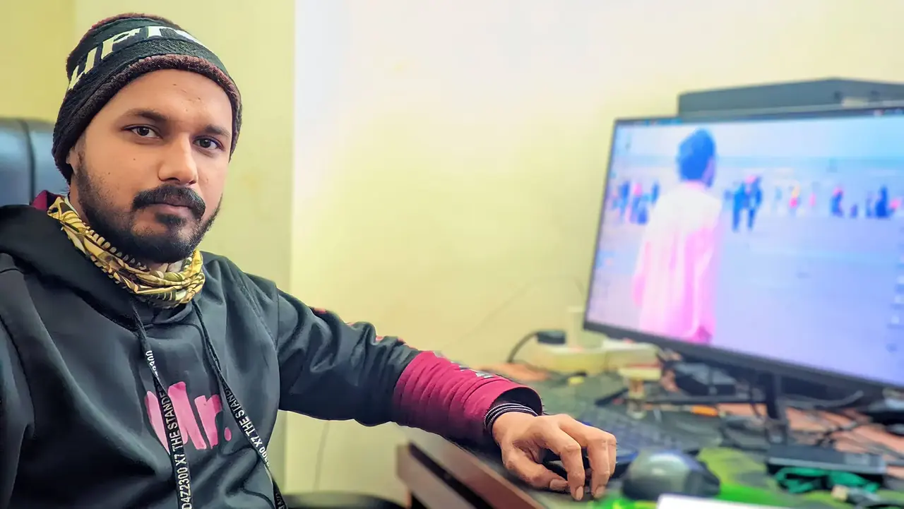 A developer at his desk with code open on the monitor